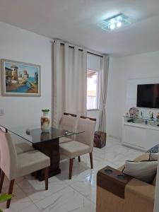 a living room with a glass table and chairs at Aconchego em Maricá in Maricá