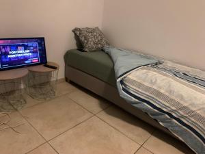 a bedroom with a bed and a television in a room at Chambre Lux in Luxembourg