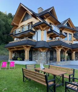a cat sitting on a bench in front of a house at GreenHill Bachleda in Zakopane