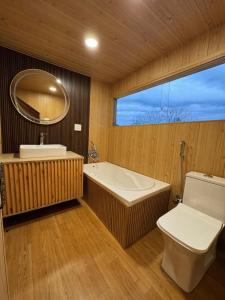 a bathroom with a tub and a toilet and a mirror at Weather cottage in Srinagar