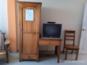 a television sitting on a desk with a wooden cabinet at Hospedaje Las Garzas in Ibarra