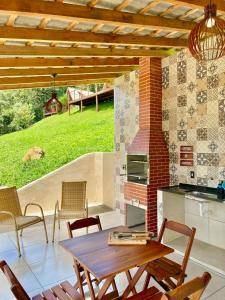 a patio with a table and chairs and a stove at Casa Araucária in Cunha