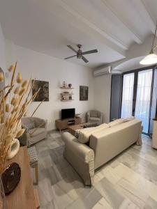 a living room with a couch and a ceiling fan at Casa Palacio Caballeros in Sanlúcar de Barrameda