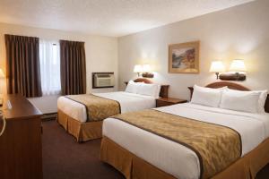 a hotel room with two beds and two lamps at Lone Tree Inn in Sidney +19 photos