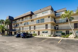a large apartment building with cars parked in a parking lot at Beachfront! Indian Rocks Beach Condo w/ Balcony in Clearwater Beach