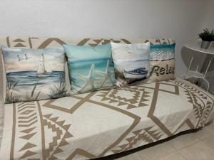 a bed with pillows on it in a bedroom at Apartamentos Amy 5 in Huelva