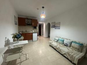 a living room with a couch and a kitchen at Apartamentos Amy 5 in Huelva