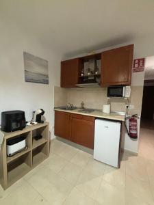 a small kitchen with a counter and a refrigerator at Apartamentos Amy 5 in Huelva +37 photos