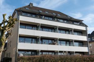an apartment building with people on the balcony at Encore Seaside in Büsum