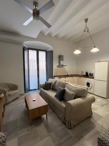 a living room with a couch and a ceiling fan at Casa Palacio Caballeros in Sanlúcar de Barrameda