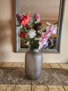 a vase filled with flowers in front of a mirror at Lescalier 513 Luxury sea facing unit in Amanzimtoti