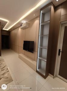 a room with a flat screen tv and a shelf at Pure Stay House in Taif
