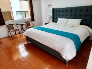 a bedroom with a large bed and a table and chairs at Hostal Cusco de mis Sueños in Cusco +12 photos