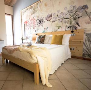 a bedroom with a large bed with a floral wall at Locanda del Borgo in Langa in Prunetto
