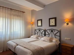 a bedroom with a large bed with white sheets at Hotel El Angliru in Cangas de Onís