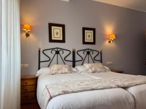 a bedroom with a bed with two pillows on it at Hotel El Angliru in Cangas de Onís
