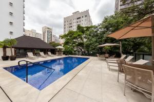 a swimming pool in the middle of a city with buildings at Victoria Place By HX in São Paulo