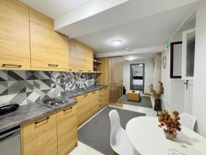 a kitchen with wooden cabinets and a white table at The Central Retreat 1 in Mytilene