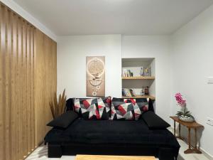 a living room with a black couch in a room at The Central Retreat 1 in Mytilene