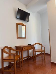a room with a table and two chairs and a mirror at Hotel El Angliru in Cangas de Onís +34 photos