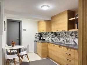 a kitchen with wooden cabinets and a table with chairs at The Central Retreat 1 in Mytilene