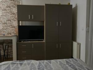 ein Schlafzimmer mit einem großen Schrank, auf dem ein Fernseher steht in der Unterkunft Dunja Doboj in Doboj