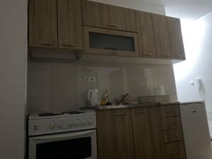 eine Küche mit Holzschränken und einem Herdofen in der Unterkunft Dunja Doboj in Doboj