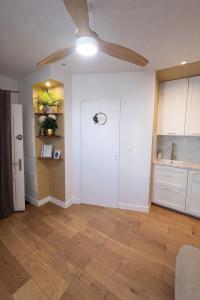 a living room with a white door and a ceiling fan at Studio cocooning in Lunel