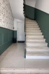 a staircase in a room with green walls and a door at Studio cocooning in Lunel +29 photos
