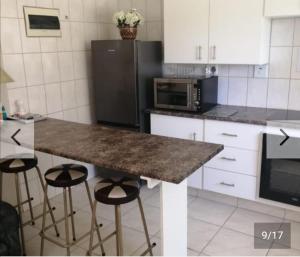 a kitchen with a counter with stools and a refrigerator at Hollywood Heights Accommodation in Barrydale