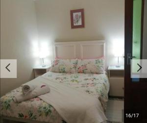 a bed in a bedroom with two lamps on two tables at Hollywood Heights Accommodation in Barrydale