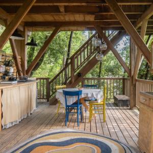 a wooden deck with a table and chairs on it at Orion Treehouses in Saint Paul de Vence