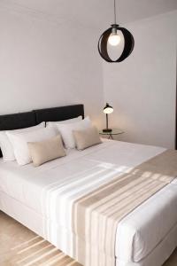 a large white bed with two pillows and a lamp at Abril Nerja in Nerja