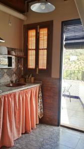 a kitchen with a counter with a sink and a window at Castor y Polux in El Gastor