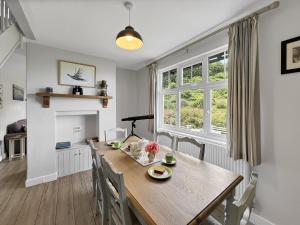 a kitchen and dining room with a wooden table and chairs at West Wind Porlock in Porlock