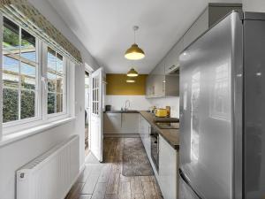 a kitchen with white cabinets and a large window at West Wind Porlock in Porlock +26 photos
