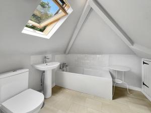 a white bathroom with a sink and a bath tub at West Wind Porlock in Porlock