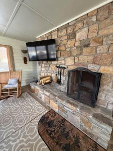 a living room with a stone fireplace with a flat screen tv at Effortless access to ski slopes•Endless relaxation in Beech Mountain +14 photos