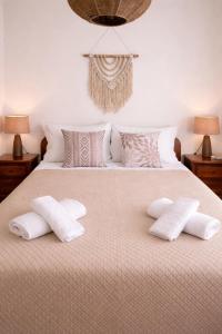 a bedroom with a bed with two pillows on it at Sounio Garden Retreat in Panayía