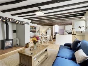 a living room with a blue couch and a fireplace at The Old Malt House Exton in Exton