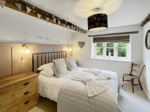 a bedroom with a bed and a chair and a window at The Old Malt House Exton in Exton