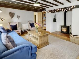 a living room with a blue couch and a fireplace at The Old Malt House Exton in Exton