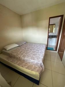 a small bedroom with a bed and a window at Apt Pituba 500m Praia in Itacaré