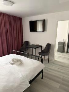 a bedroom with a bed and two chairs and a table at Hotel MARSO in Almaty