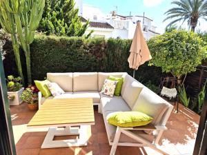 a patio with a couch and a table and an umbrella at Casa Tranquila La Duquesa in Manilva