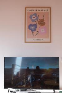 a computer monitor on a desk with a picture on the wall at Spacious Lovely Apartment in Sarandë