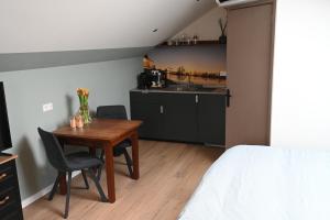 a room with a table and chairs and a kitchen at Cetti's Lodge - met privé sauna in Nieuwkoop +31 photos