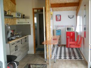 a kitchen with a table and a red refrigerator at chalet nature 2 in Aspiran