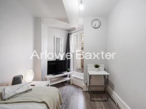 a bedroom with a bed and a clock on the wall at Hackney Guest Rooms in London +14 photos