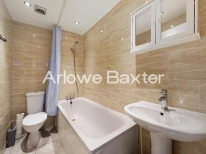 a bathroom with a sink and a tub and a toilet at Hackney Guest Rooms in London